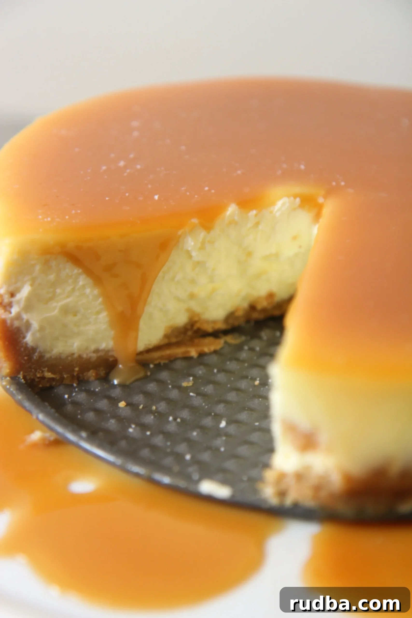 A beautifully sliced salted caramel cheesecake, rich and creamy, served on a springform pan.