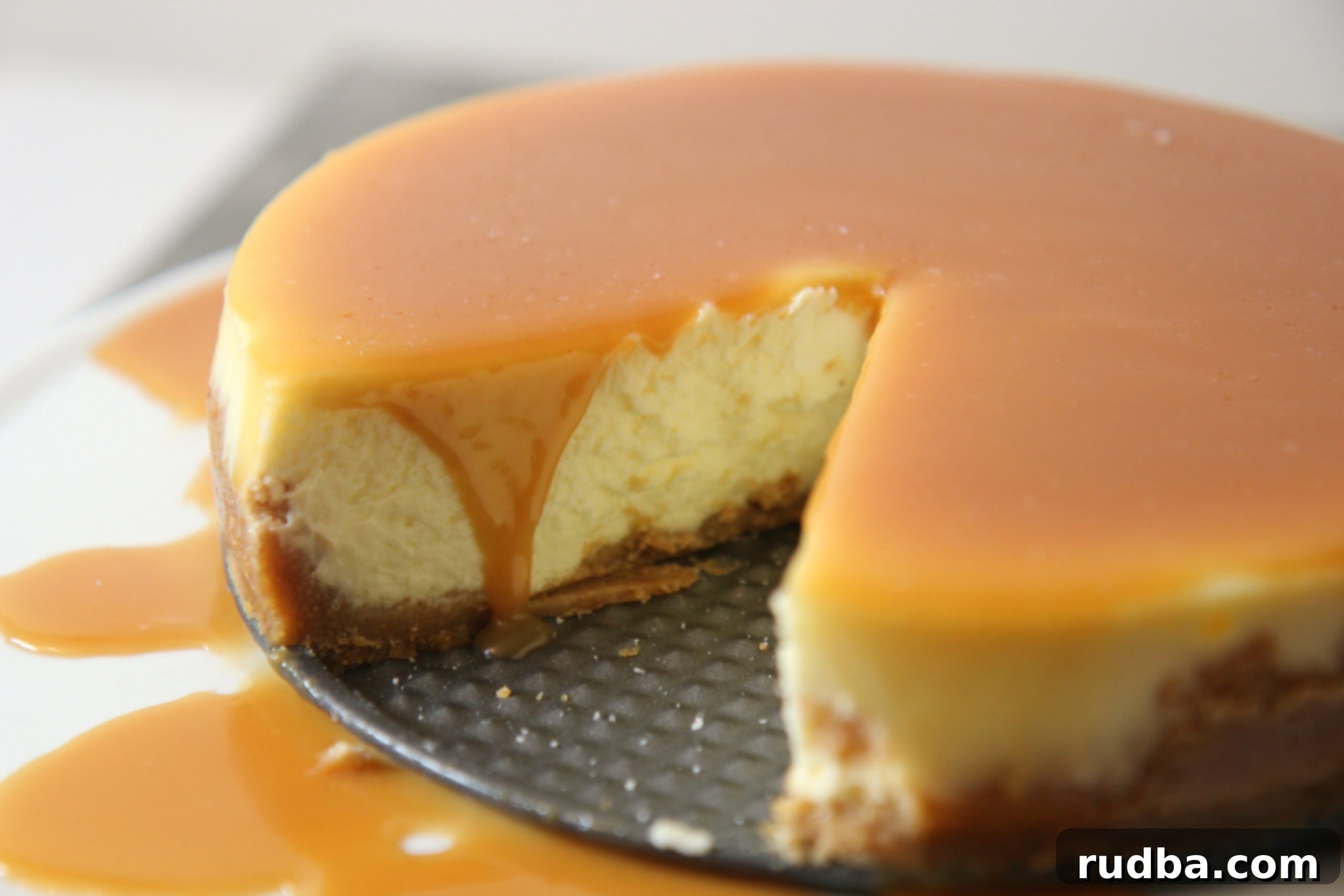 Close-up view of the salted caramel cheesecake, highlighting the thick caramel layer and coarse sea salt sprinkles.