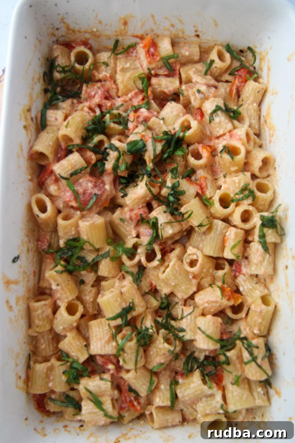 baked feta pasta in a 9x13 baking dish, showcasing the creamy sauce and tomatoes