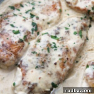 Decadent Garlic Parmesan Chicken 4 two creamy garlic parmesan chicken breasts with parsley on top.