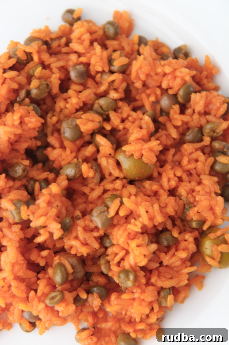 Arroz con Gandules - Rice and Pigeon Peas 4 yellow rice with pigeon peas on a white plate up close.