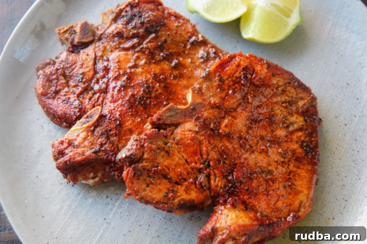Two fried pork chops up close, showing their crispy texture and golden-brown color.
