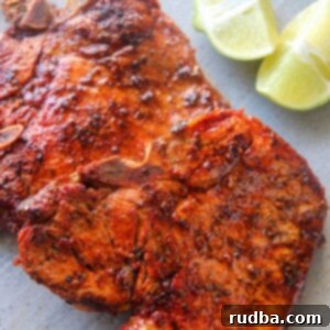 Deep Fried Pork Chops 4 two chuletas fritas on a gray plate with two lime wedges.