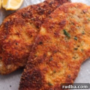Golden Crispy Chicken Cutlets 5 two crispy chicken cutlets with a lemon wedge on the side.