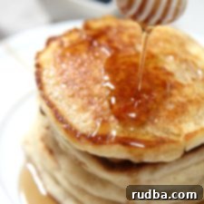 Classic Homestyle Pancakes 4 5 stacked pancakes on a plate with a honey comb over it