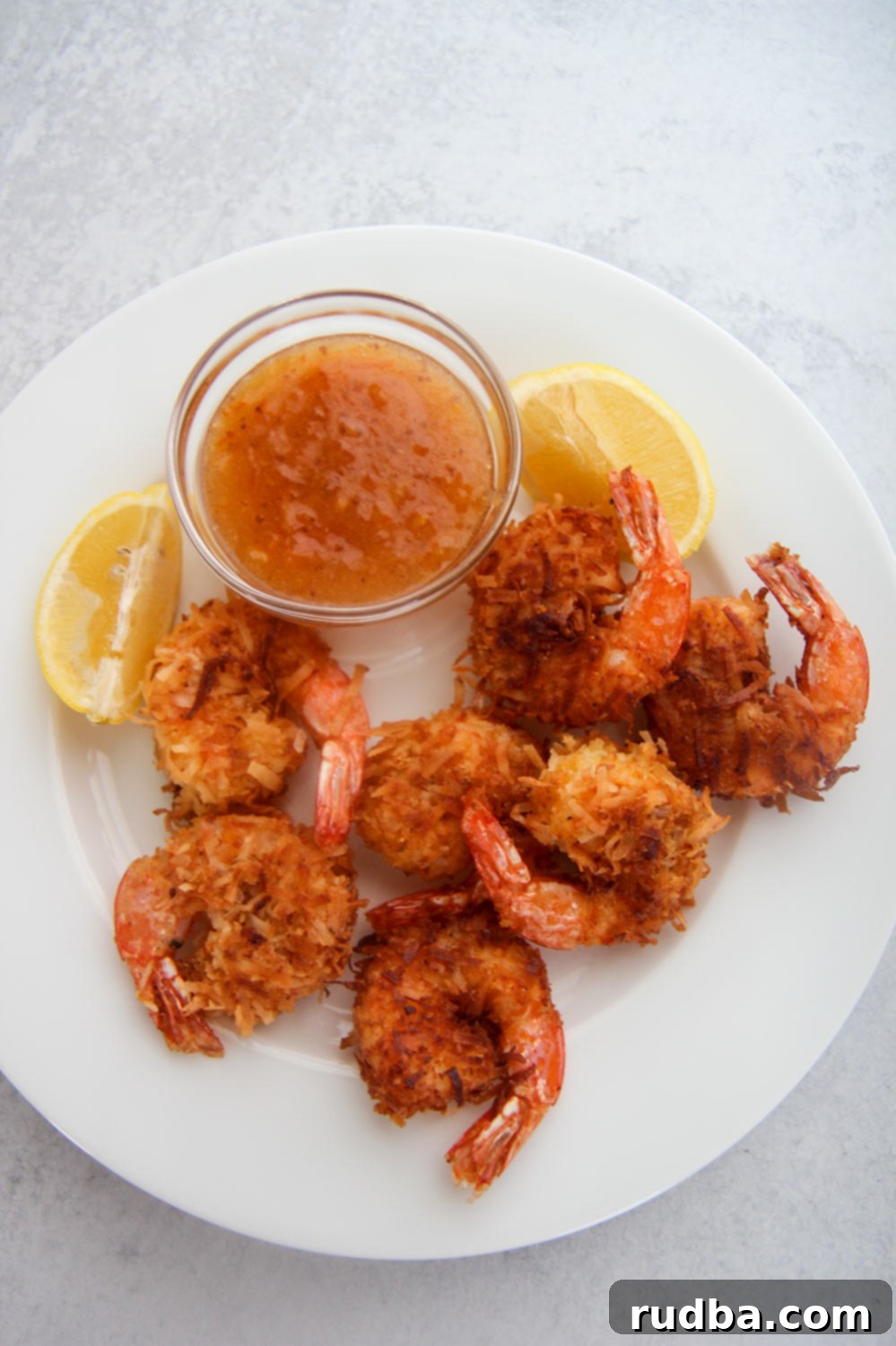A close-up shot of a plate of perfectly fried coconut shrimp.