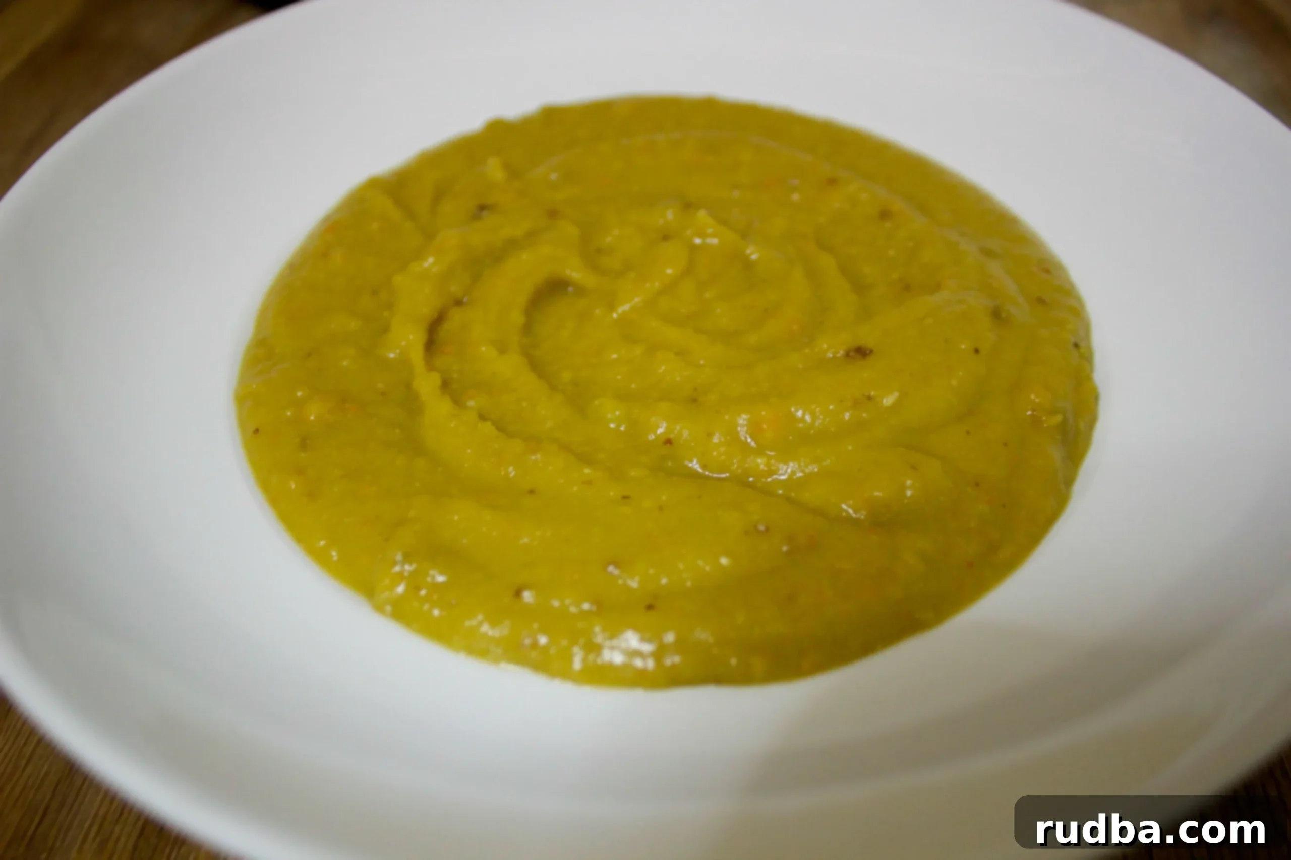 A vibrant bowl of spicy split pea soup, garnished with fresh herbs, perfect for a cozy meal.