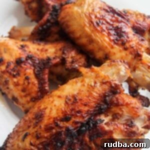 4 air fried turkey wings on a white plate.