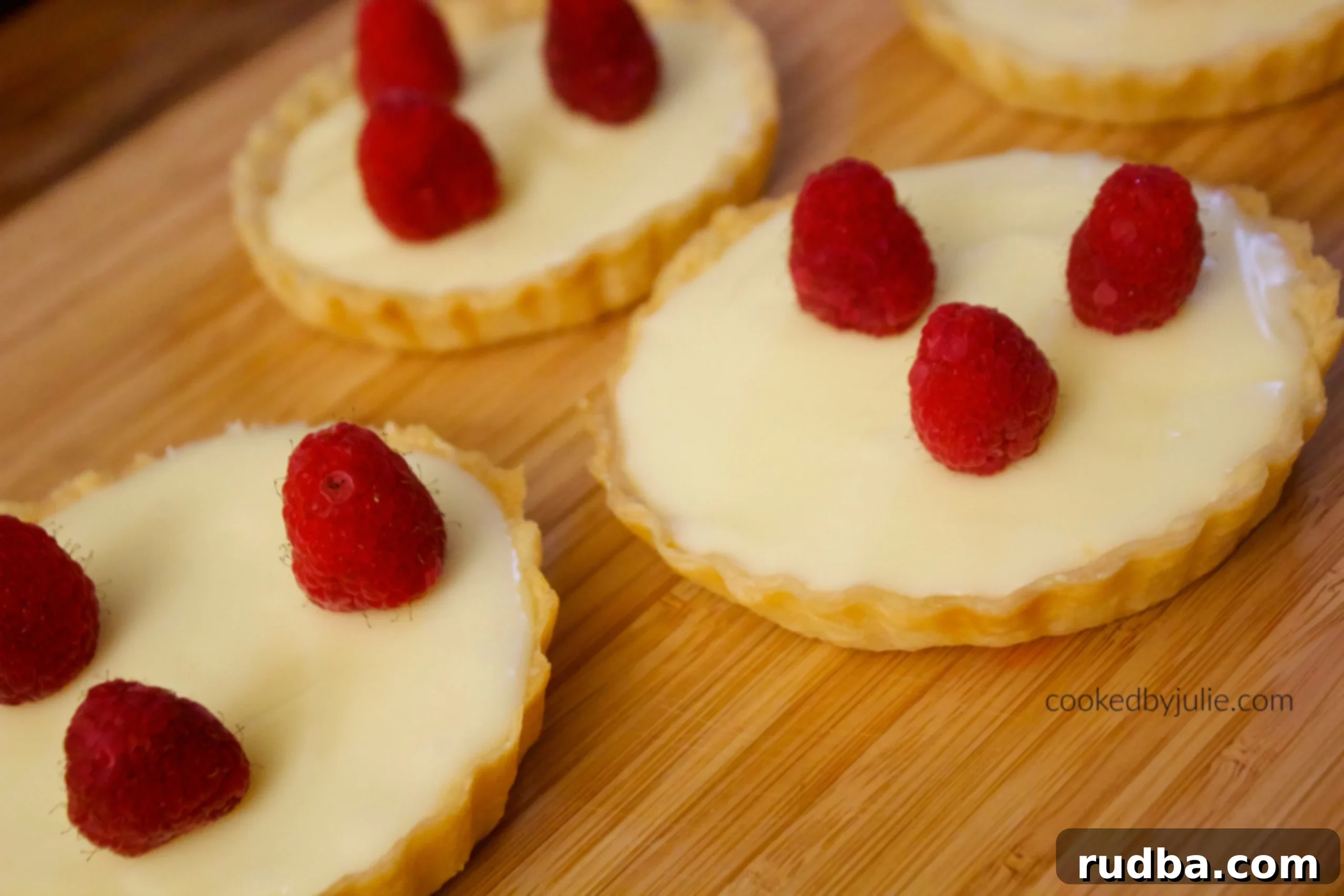 Delightful white chocolate tarts with fresh raspberries, showcasing their creamy texture and elegant presentation.