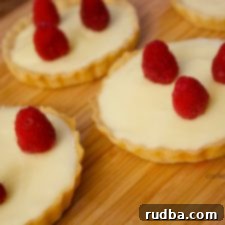 A perfectly portioned White Chocolate Tart with a vibrant raspberry topping.