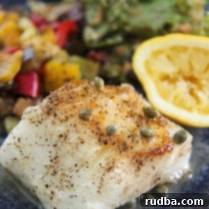 Silken Pan Seared Chilean Sea Bass 2 Chilean sea bass with vegetables, salad, and lemon.