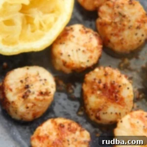 Crispy Air Fryer Scallops 2 air fryer scallops with a lemon on the side.