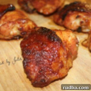 Sweet Heat Honey Chicken Bake 3 five spicy honey baked chicken thighs on a wooden board. One chicken thigh up close.
