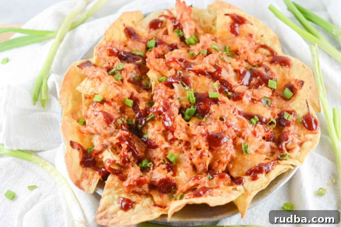 a large platter with barbecue chicken nachos and scallions on the side 