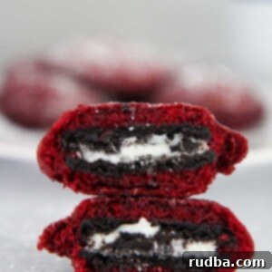 Two red velvet fried Oreos stacked on top of each other, dusted with powdered sugar.