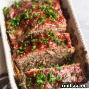 Homestyle Meatloaf 2 sliced meatloaf with fresh parsley on top.