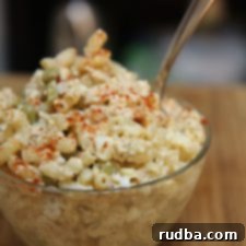 Creamy Classic Macaroni Tuna Salad 4 Close-up of creamy macaroni tuna salad with a sprig of fresh herb garnish.