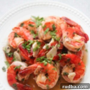 Sizzling Garlic Shrimp 2 Camarones al Ajillo on a white plate with cilantro on top.