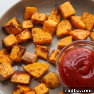 Air Fryer Sweet Potato Perfection 2 air fryer sweet potatoes with a side of ketchup.