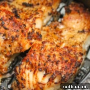 Two cooked Chilean sea bass fillets in an air fryer basket.