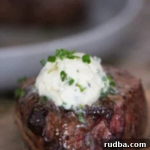 Perfect Air Fryer Filet Mignon 2 air fryer filet mignon with garlic butter on top.