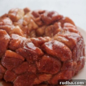 Gooey Caramel Pull Apart Bread 2 A warm, golden caramel monkey bread on a white plate, ready to be pulled apart and enjoyed.