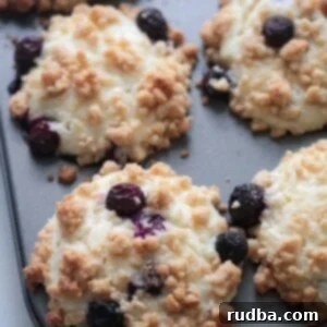 Irresistible Blueberry Cream Cheese Muffins 2 Baked blueberry cream cheese muffins in a muffin tin.