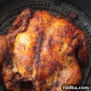 Crispy Air Fryer Whole Chicken 2 A perfectly cooked, golden-brown whole chicken presented on a plate, fresh from the air fryer.
