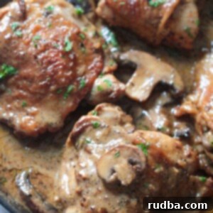 Champagne-Kissed Chicken 2 champagne chicken in a skillet with cream sauce, mushrooms, and parsley.