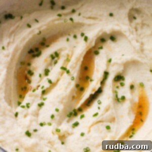 Nutty Brown Butter Mashed Potatoes 2 browned butter mashed potatoes in a dutch oven with chives on top.
