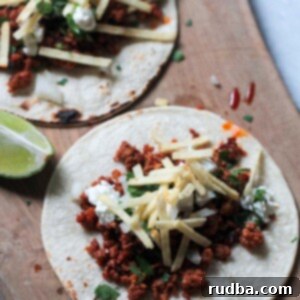 Two chorizo tacos on a wooden board.