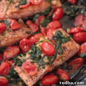 Zesty Lemon Herb Salmon with Tomatoes and Spinach 2 salmon with tomatoes and spinach in a skillet.