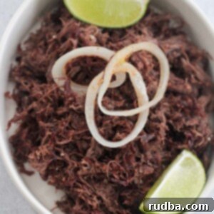 Golden Crispy Shredded Beef 2 vaca frita with grilled onions and lime wedges.
