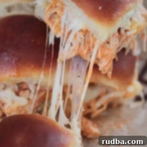 Ultimate Buffalo Chicken Sliders 2 Close-up of baked buffalo chicken sliders with melted cheese and a golden-brown top, ready to be served.