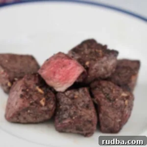 Close-up of perfectly air-fried steak tips on a plate.