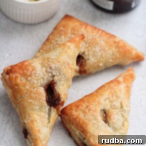 Sweet and Savory Fig and Goat Cheese Turnovers 2 Three golden brown fig and goat cheese turnovers, artfully arranged on a cooling rack.