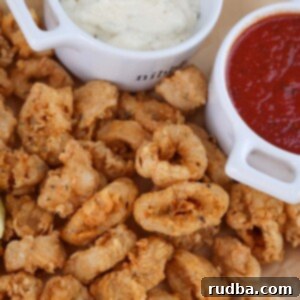 Golden Calamari Bites 2 fried calamari with a lemon wedge, marinara sauce, and tartar sauce on the side.