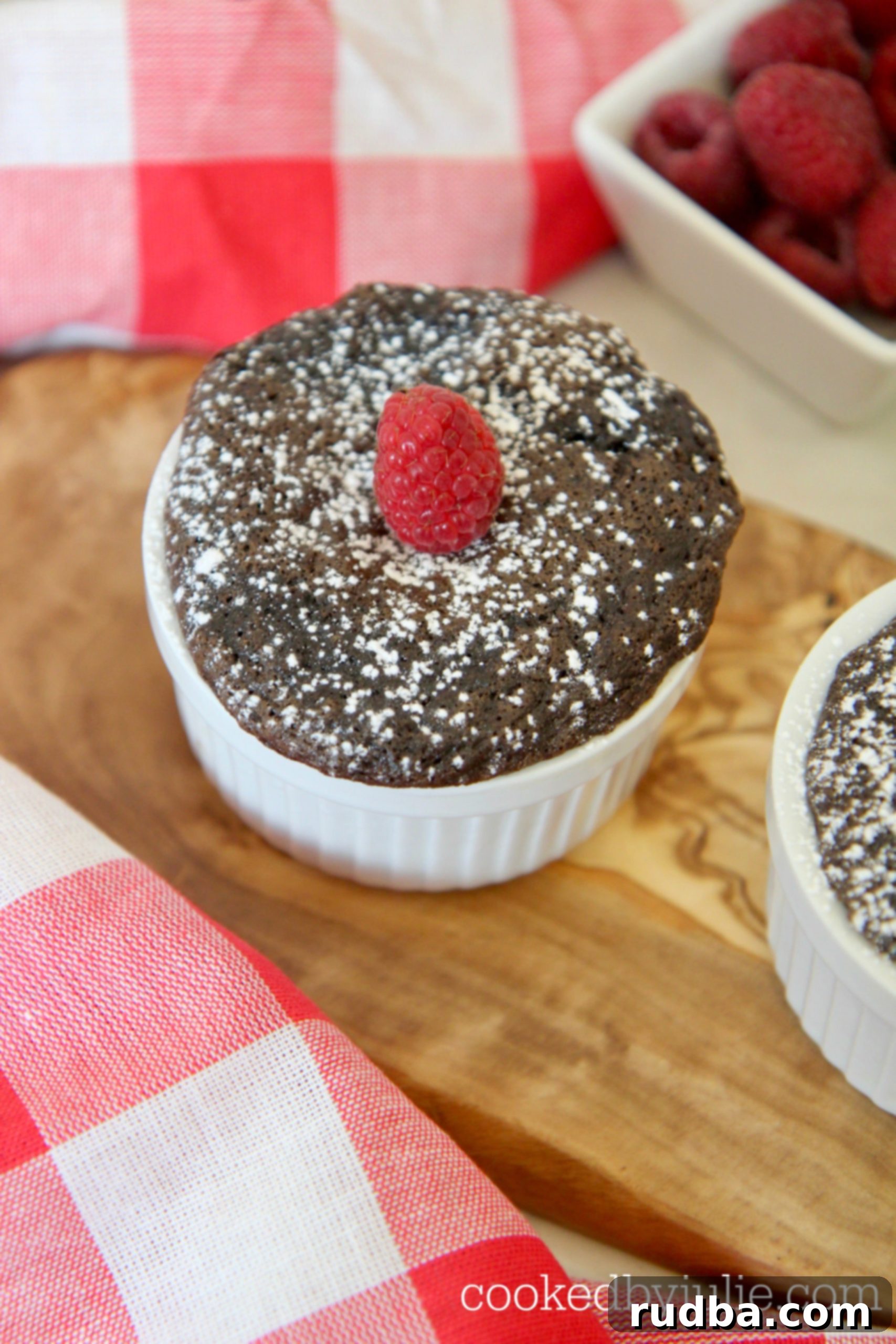 Mini Nutella cakes sprinkled with powdered sugar and topped with raspberries.
