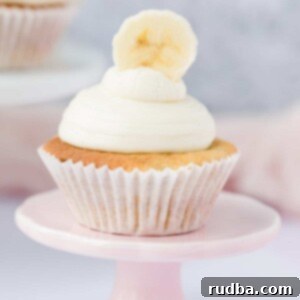 one banana cupcake on a small pink cake stand.