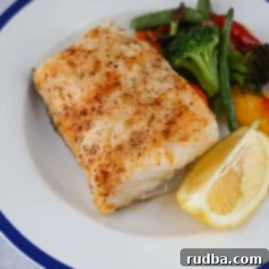 Succulent Baked Chilean Sea Bass 2 baked chilean sea bass with a lemon wedge and mixed vegetables.
