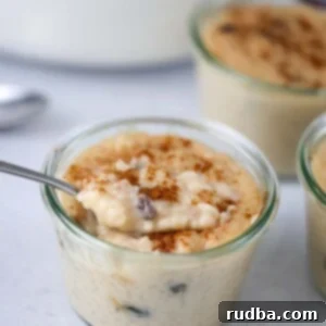 arroz con dulce in a small glass jar with a spoon.