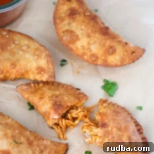 Savory Chicken Empanadas 2 four chicken empanadas with hot sauce on the side.