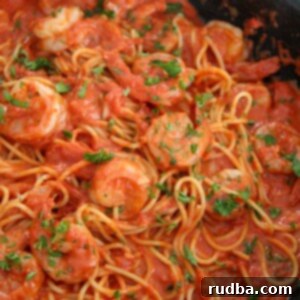Irresistible Shrimp Creations 2 Creamy spicy shrimp spaghetti with parsley in a black skillet