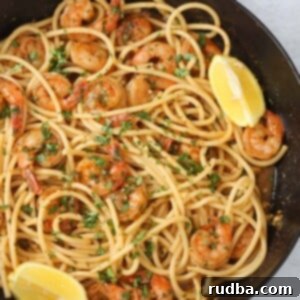 Irresistible Shrimp Creations 5 Cajun shrimp scampi with pasta in a skillet.