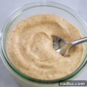 The Aioli Kick 2 spicy aioli in a jar with a spoon.