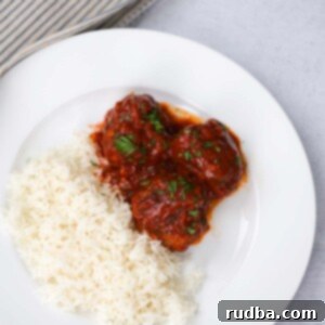 Cuban Meatballs 2 Albondigas with white rice on a white plate.