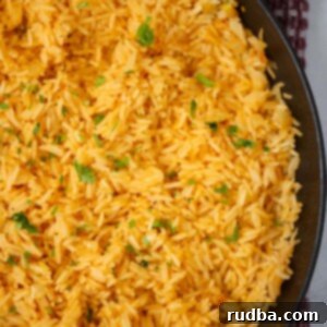 Golden Yellow Rice 2 Yellow rice in a black skillet up close.