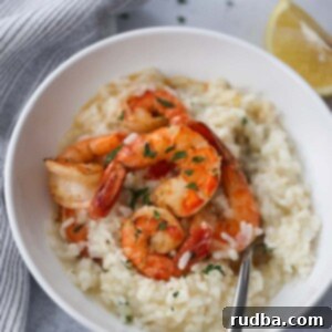 Creamy shrimp risotto served in a white bowl with a fork.