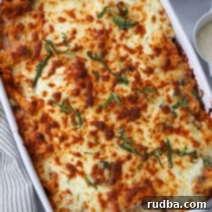 Hearty Baked Ziti Casserole 2 baked ziti in a 9x13 baking dish with cheese and red pepper flakes on the side.
