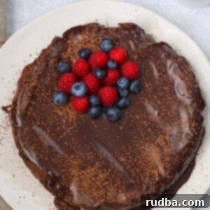 Pure Chocolate Indulgence 2 whole flourless chocolate cake with blueberries and raspberries on top.